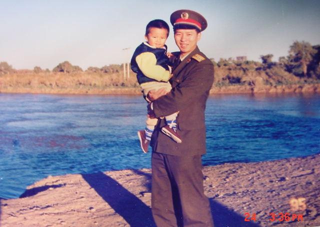 1995年，抱着孩子在河边